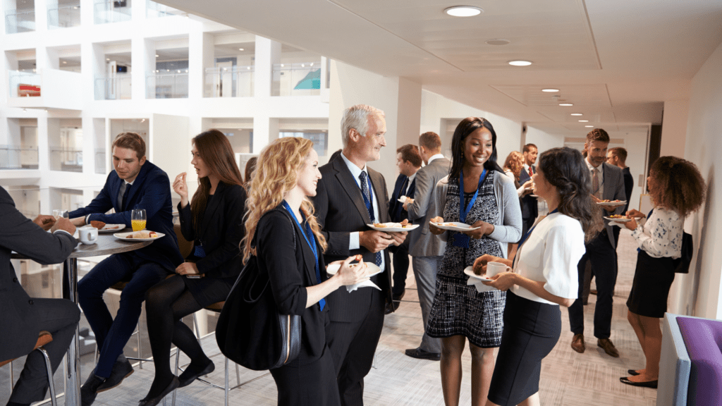 Diverse professionals networking and socializing during a business conference break.

