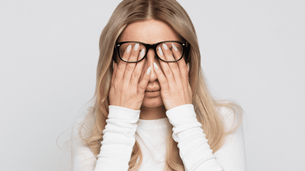 woman with glasses covering face showing signs of mental fatigue