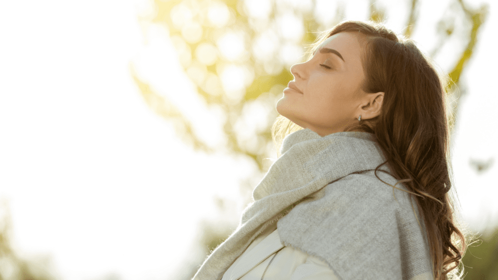 woman practicing mindfulness outdoors in natural sunlight to combat mental exhaustion

