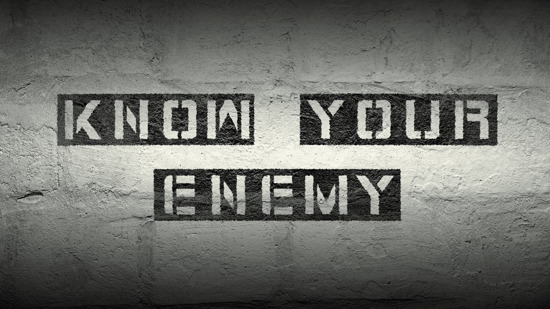 Stenciled text reading KNOW YOUR ENEMY on concrete wall