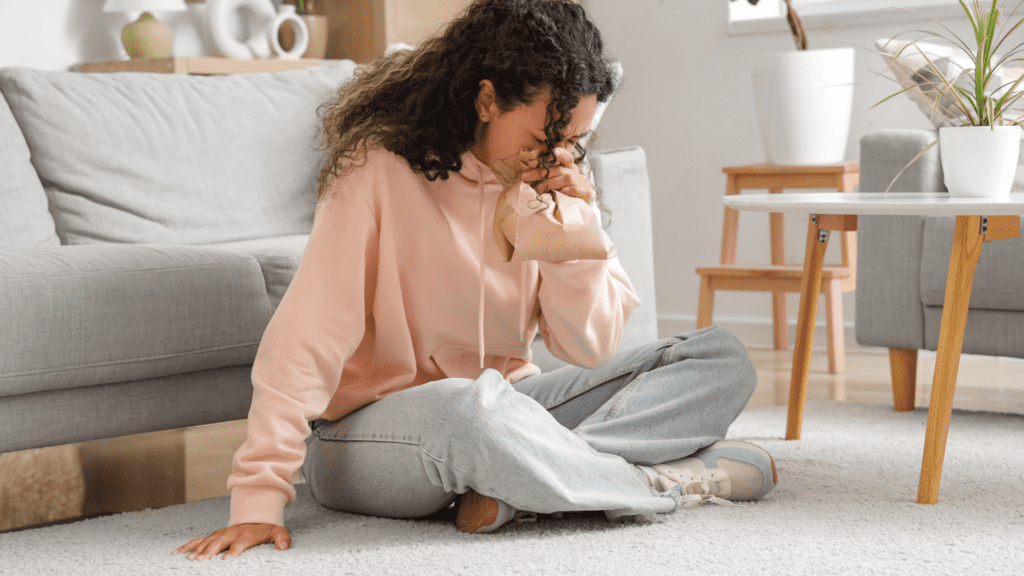 How Do You Calm Down From an Anxiety Attack? 5 Neuroscience-Based Methods 2 How do you calm down from an anxiety attack? A woman experiencing an anxiety attack sits on the floor, using a paper bag for controlled breathing.