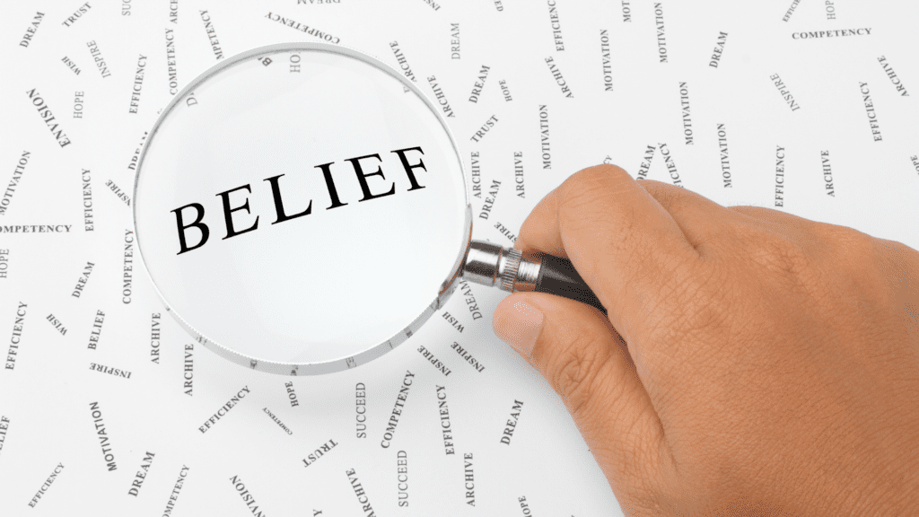 A magnifying glass highlighting the word "belief" among other motivational words.

