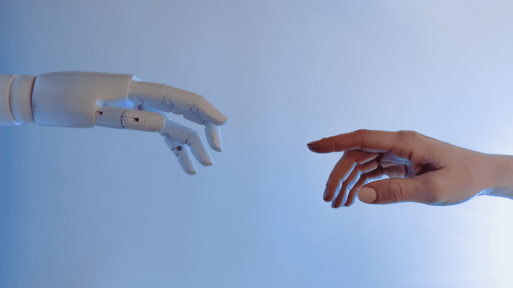 A robotic hand reaching out to touch a human hand, symbolizing the collaboration between AI and human intelligence in cognitive evolution.