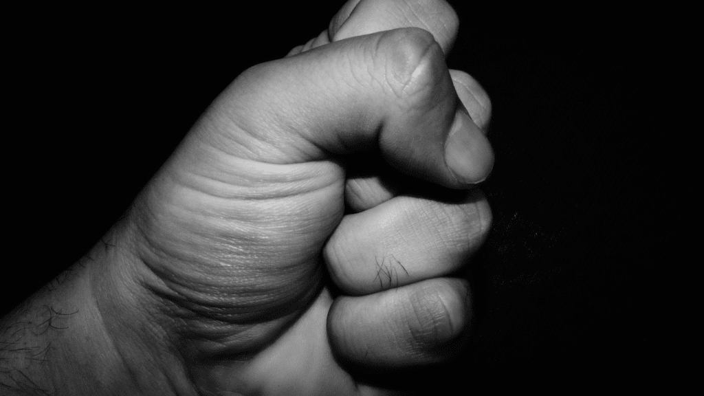 A tightly clenched fist in black and white, representing suppressed anger and tension and ways of managing anger.