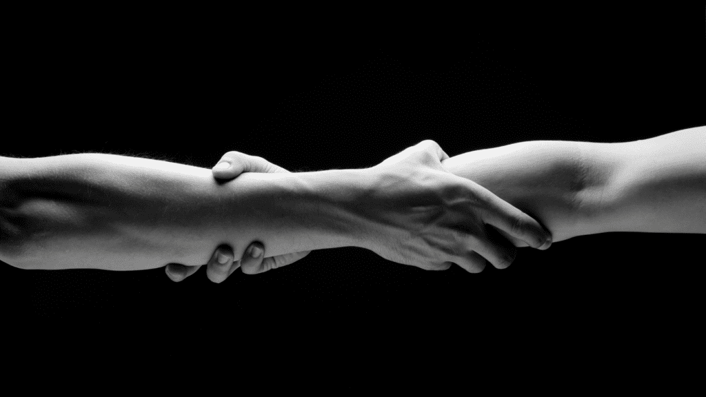 Two hands clasped tightly in black and white, symbolizing rebuilding trust and emotional connection.