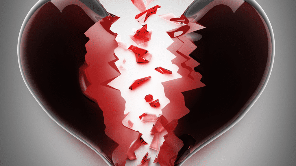 A 3D-rendered heart breaking into pieces, with sharp, jagged fragments falling away, symbolizing the deep emotional impact of betrayal. The red hues emphasize passion, love, and the pain of a fractured bond.