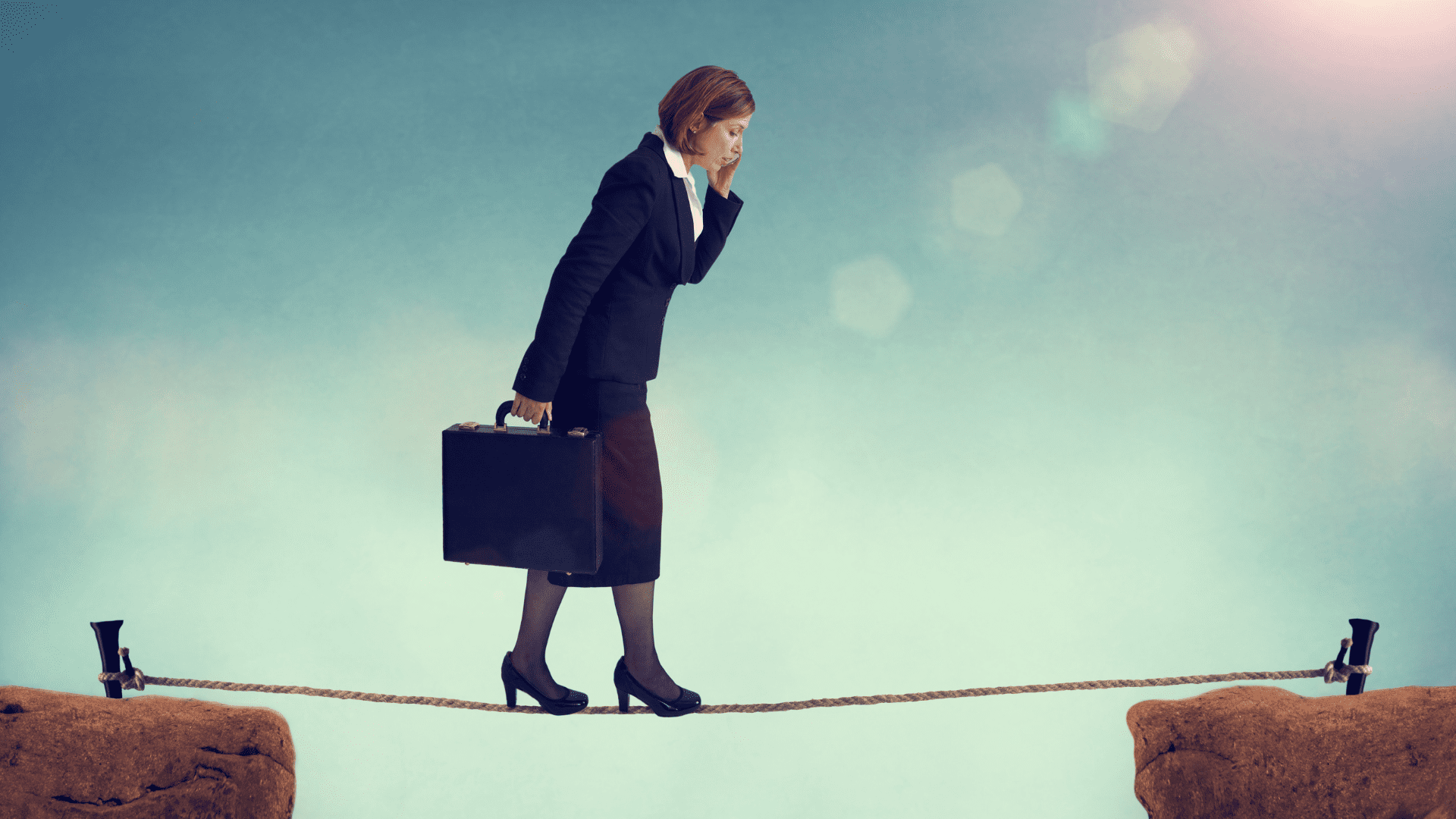 A businesswoman walking a tightrope over a gap, representing the fine line between fear and opportunity in risk-taking.