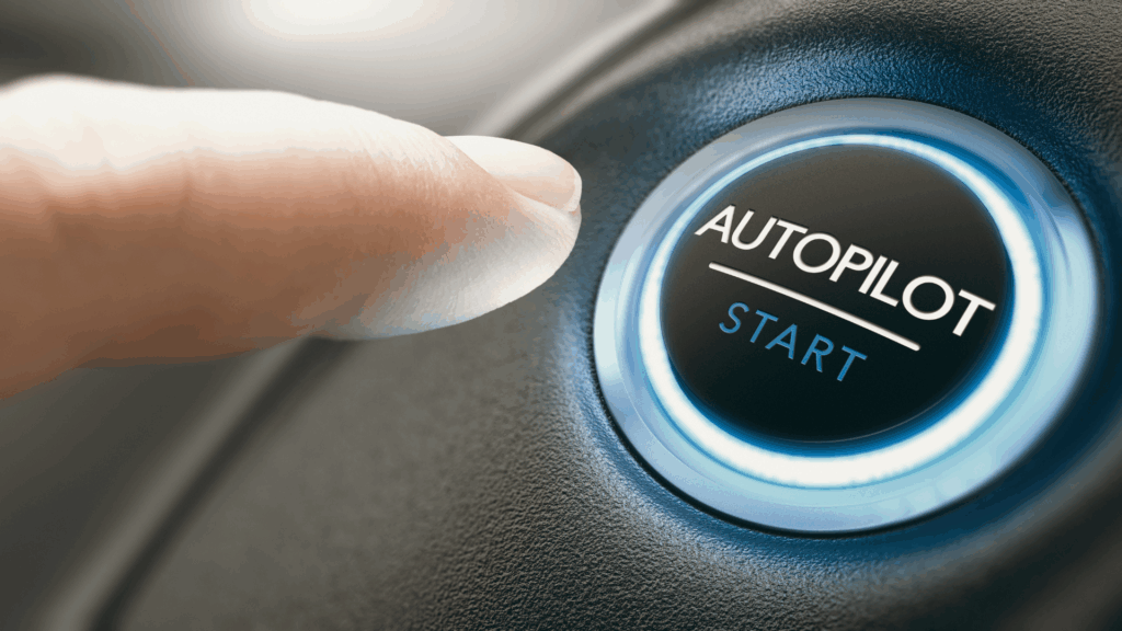 Finger pressing an illuminated Autopilot Start button, representing the ease of slipping into autopilot mode in daily life.