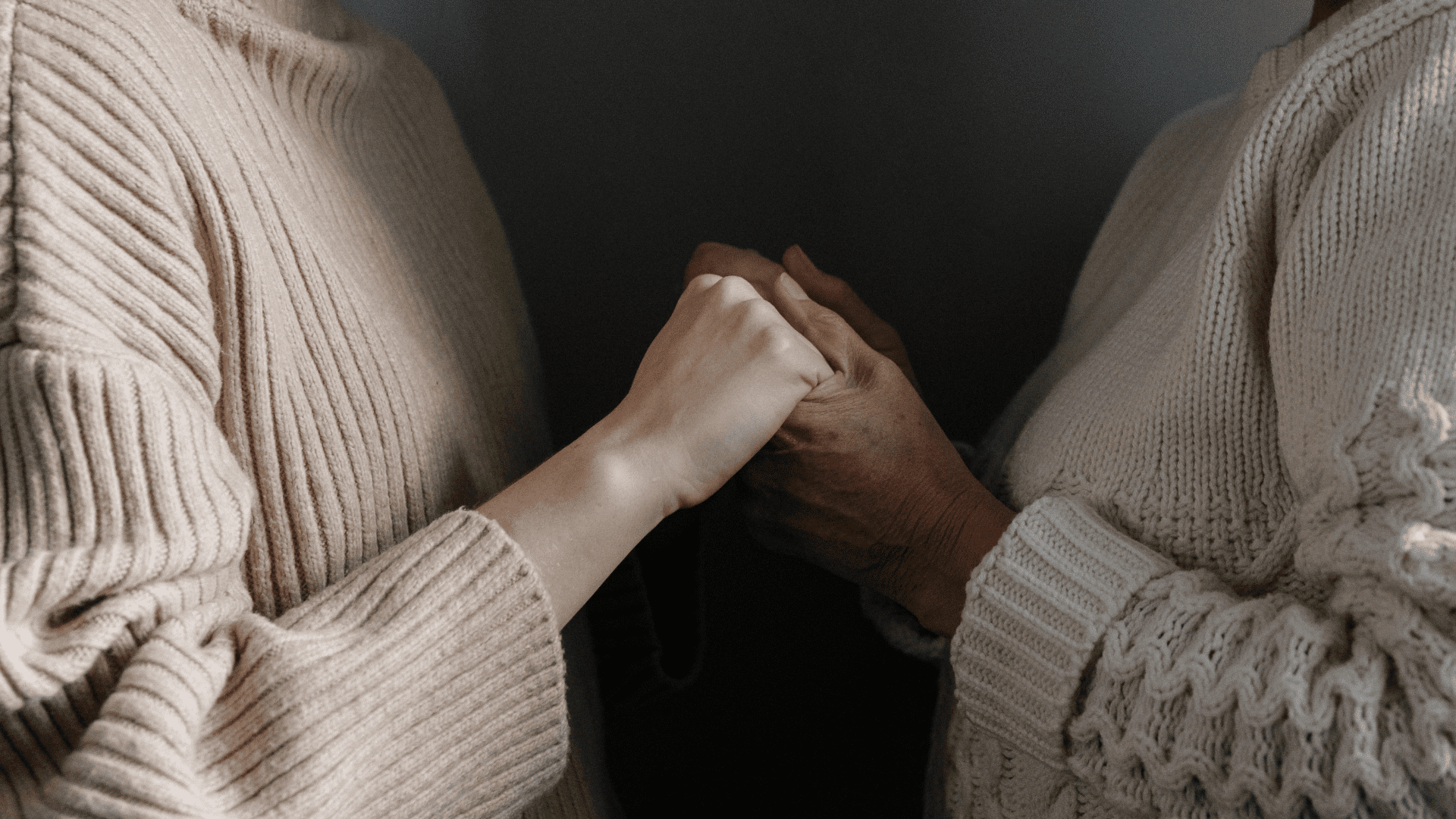 Two people holding hands for emotional support during reassurance-seeking