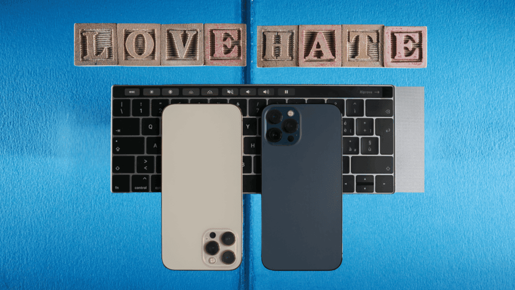 Two smartphones placed on a laptop keyboard with wooden blocks spelling "LOVE" and "HATE," symbolizing the complex relationship with technology and the need for a digital detox.




