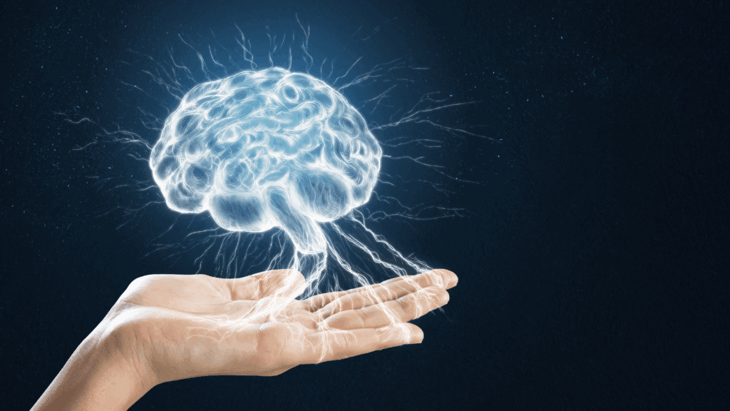 How the Brain Drives Motivation: Unlocking Your Potential with Neuroscience 3 Open hand supporting an illuminated brain, symbolizing how the brain drives motivation and powers human achievement.