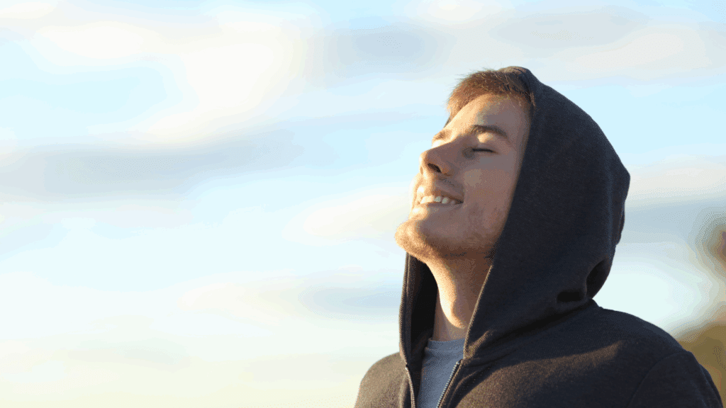 Mindfulness for Anxiety: Neuroscientific Insights & Practical Strategies 5 Young man with closed eyes looking upward peacefully, showing the calm achieved through mindfulness for anxiety.