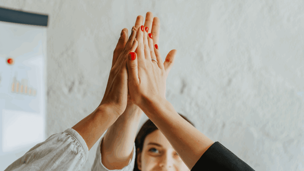 The Neuroscience of Taking the High Road: Why Choosing Integrity Changes Your Brain and Life 4 Group high five celebrating teamwork and the neuroscience of taking the high road