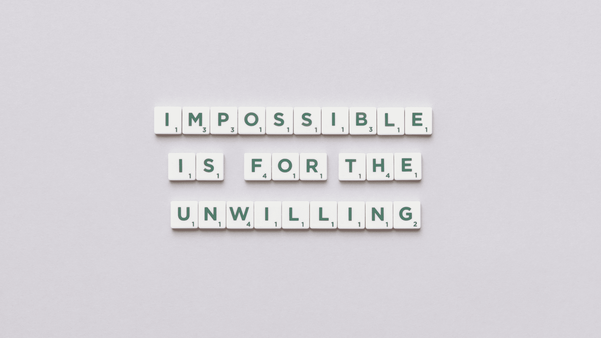 Scrabble tiles spelling “Impossible is for the unwilling” representing mindset mastery