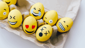 Yellow eggs painted with expressive emoji faces symbolizing creative expression for anxiety and emotions.
