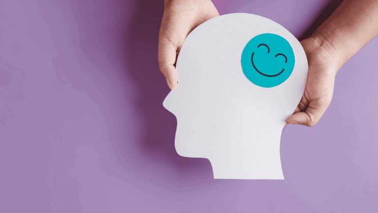 On the Blog 8 Paper cutout of a human head with a happy face symbol, representing the dopamine paradox in brain reward systems.