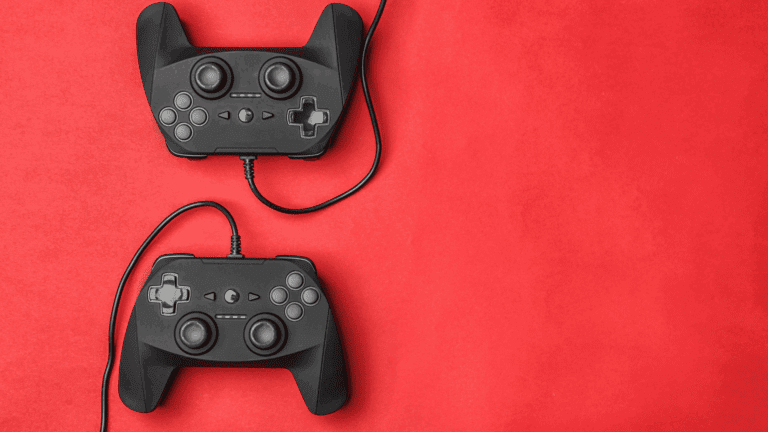 Two black gaming controllers on a red background symbolizing the use of gamified learning for education and engagement.