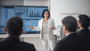Businesswoman presenting data charts to colleagues, illustrating leadership and the neuroscience of emotional awareness.