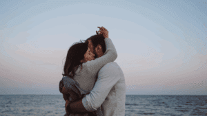 Romantic couple embracing on a beach at sunset, symbolizing connection and intimacy in the neuroscience of sex.