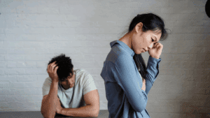 Recovering From a Break Up: Brain‑Based Healing 1 Couple sitting apart in distress, symbolizing the emotional pain of recovering from a break up.