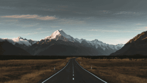 Wanting Versus Needing in Relationships: Transform Your Connections 2 Open road leading to snow-capped mountains, symbolizing the journey of wanting versus needing in life goals.