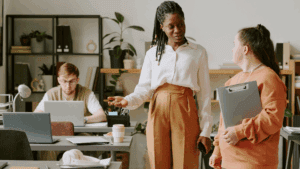 Dopamine-Aware Leadership: Neuroscience for Motivating Teams 1 “Leader mentoring team members in a supportive office, demonstrating positivity in Dopamine-Aware Leadership.”