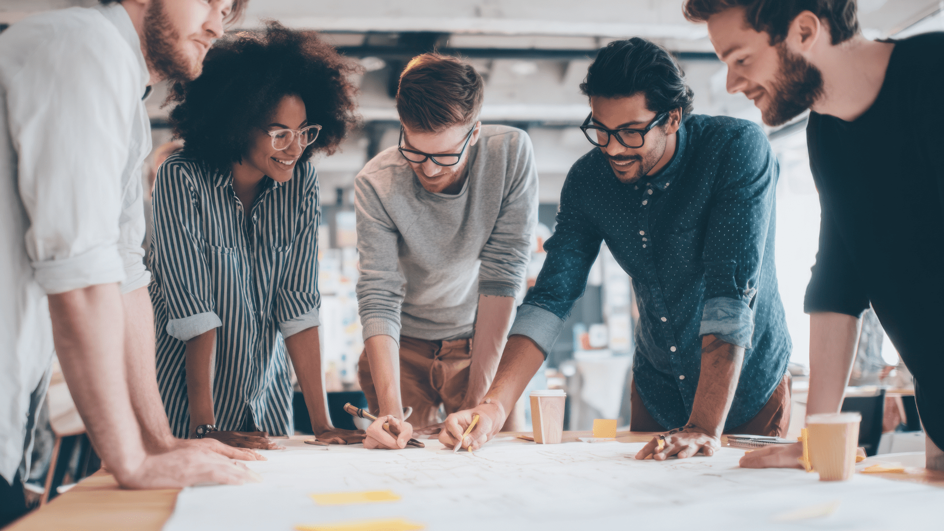 “Diverse team collaborating enthusiastically around a table, representing teamwork driven by Dopamine-Aware Leadership.”