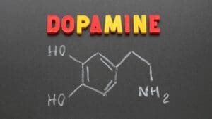 “Dopamine chemical structure drawn in chalk on a blackboard with colorful letters spelling dopamine, symbolizing Dopamine Coaching Neuroscience.”
