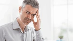 Man holding his head in frustration, symbolizing mental strain and internal conflict in the neuroscience of contentiousness.