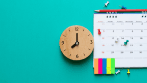 Wooden clock and calendar with colorful notes symbolizing time management and planning in virtual wellness coaching tips.