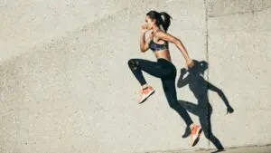 Athletic woman running outdoors, symbolizing forward movement and breaking free from the limits of what if thinking.