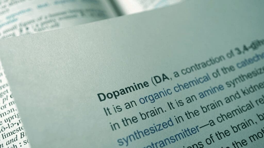 Close-up of dopamine chemical definition and molecular structure showing dopamine as an organic compound synthesized in the brain and its neurotransmitter function.
