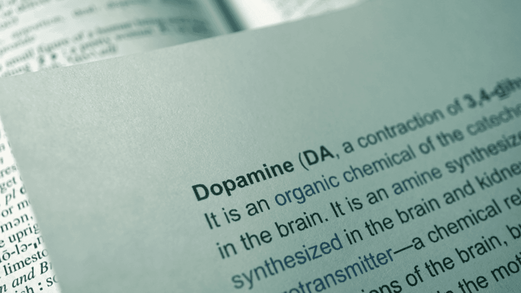 Close-up of dopamine chemical definition and molecular structure showing dopamine as an organic compound synthesized in the brain and its neurotransmitter function.

