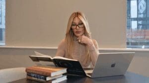 Professional neuroscience coach preparing for first brain-based coaching session at desk with research materials.