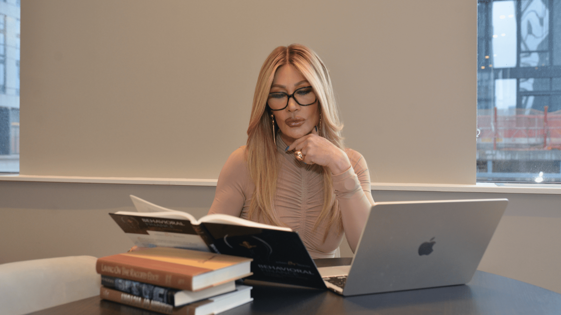 Professional neuroscience coach preparing for first brain-based coaching session at desk with research materials.
