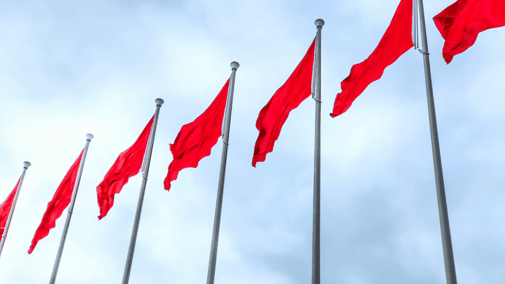 Red flags representing warning signs when choosing neuroscience coach vs therapist.