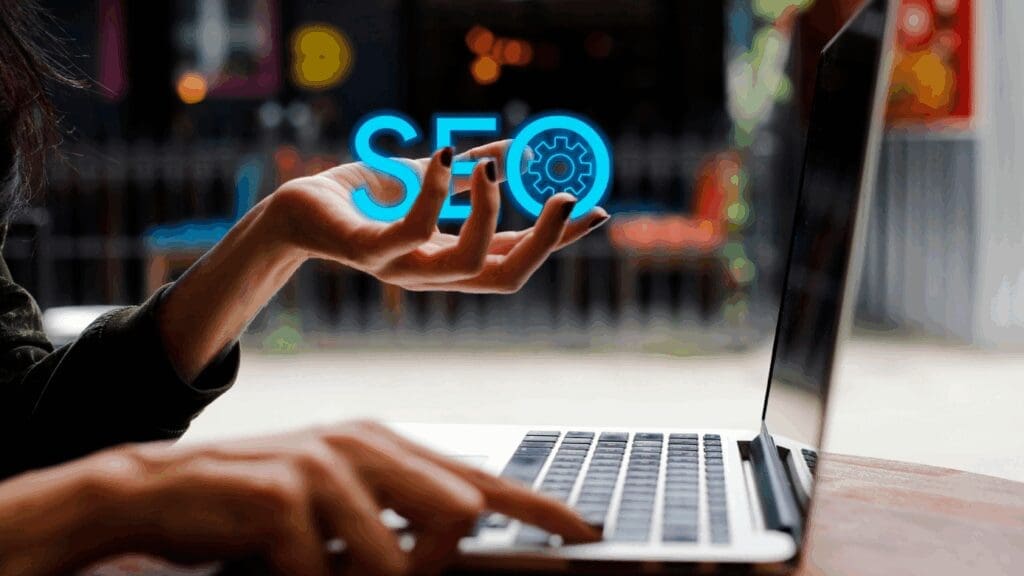 A woman working on a laptop holds a digital SEO icon, symbolizing topical authority in neuroscience-based coaching.