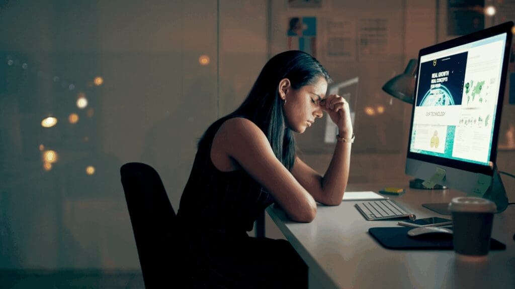 Stressed executive experiencing burnout affecting dopamine workplace performance at night.